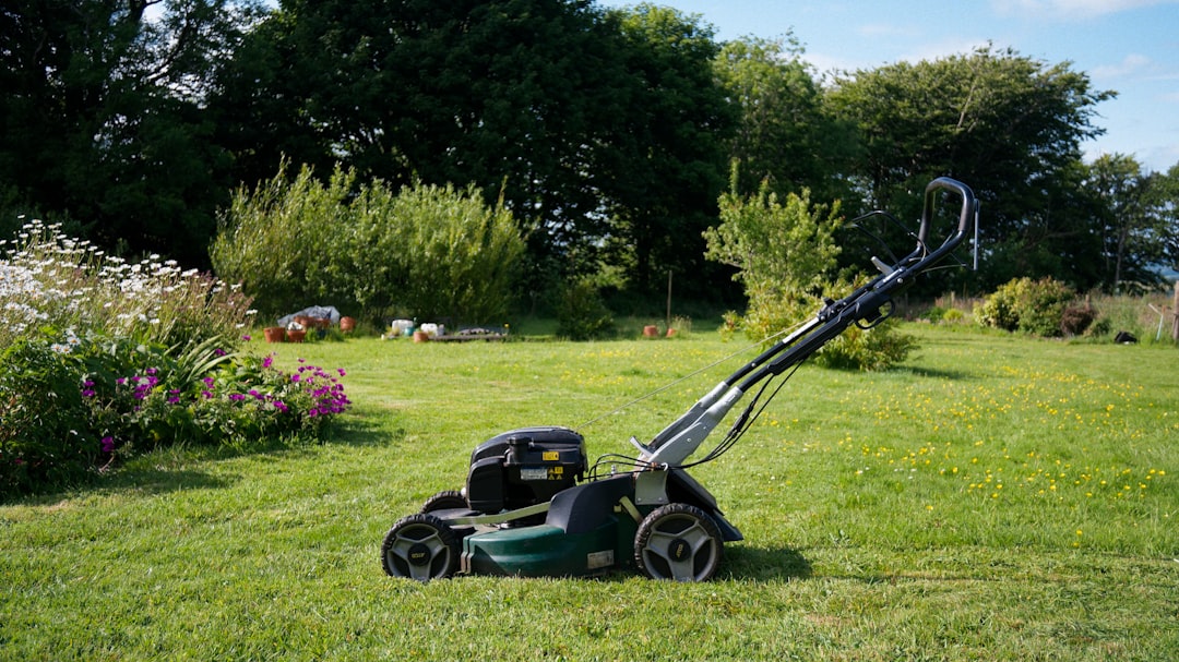 A lawnmower sits on a grassy lawn.