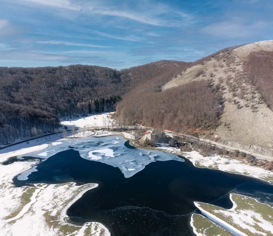 an aerial view of a lake surrounded by mountains
