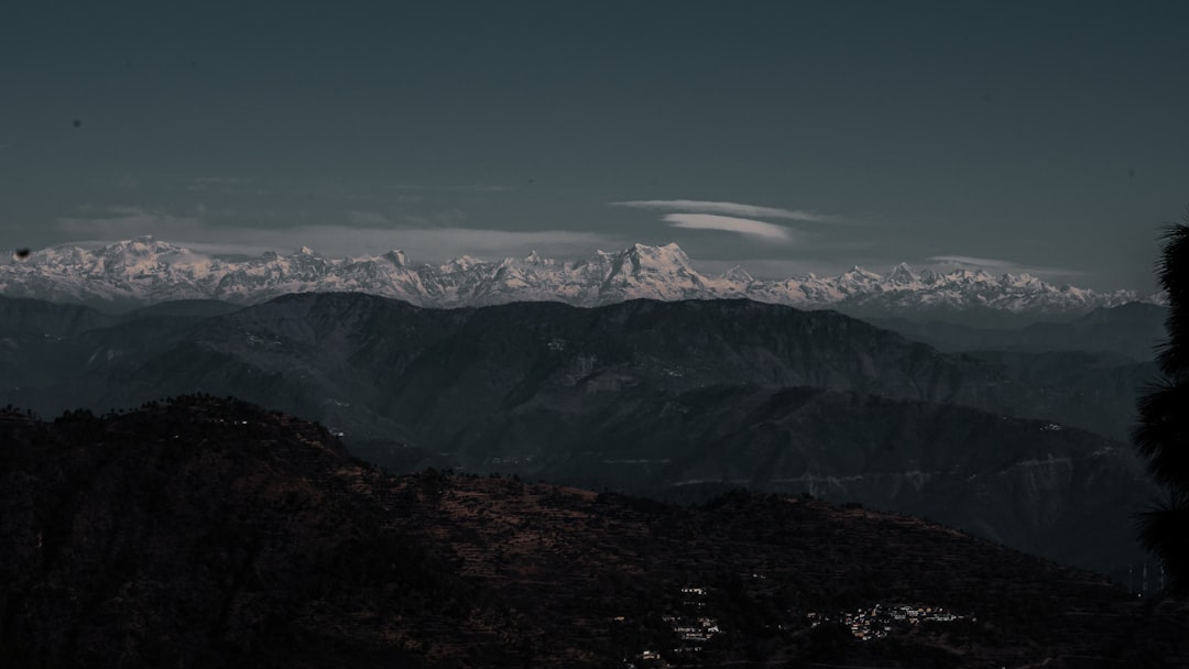a view of a mountain range with snow capped mountains in the distance